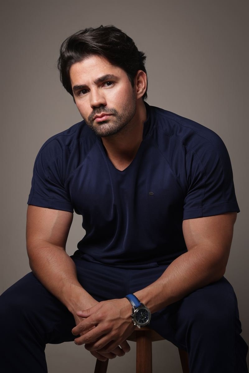 Dr. Felipe Carega sentado, de camiseta azul-marinho